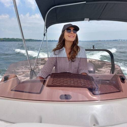 Lara Mcculloch Toronto marketing agency founder, laughing, wearing a hat, driving a boat