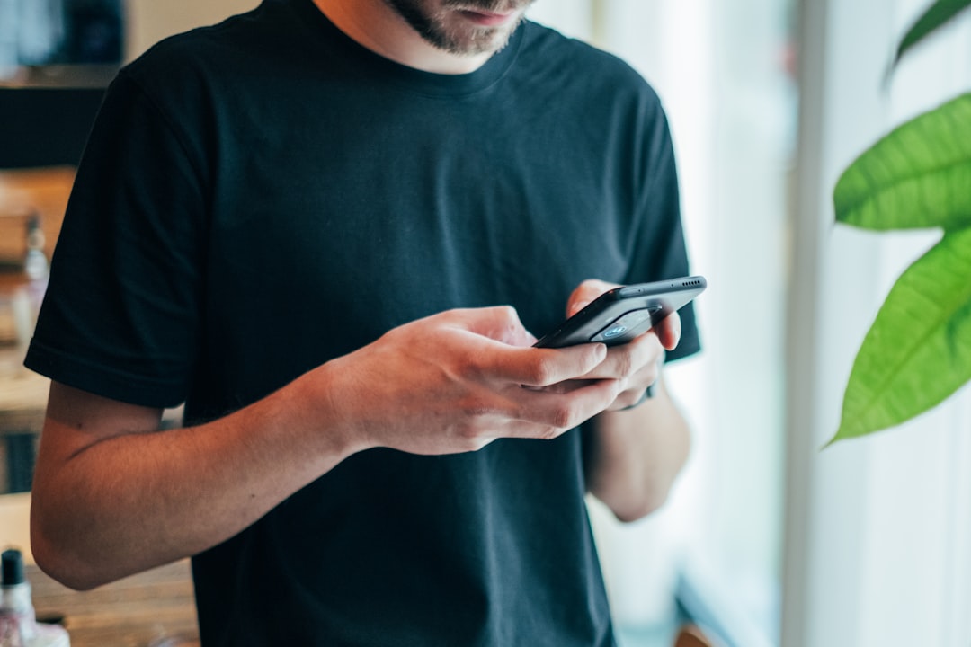 Person scrolling a smartphone screen while standing indoors